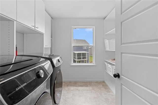 laundry room with cabinet space, washing machine and clothes dryer, and baseboards