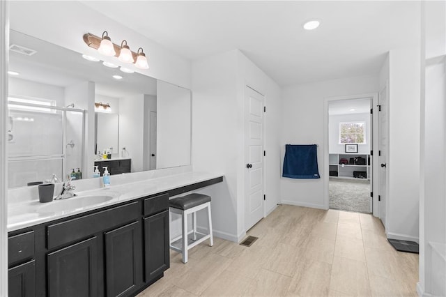 bathroom with a shower stall, vanity, and baseboards