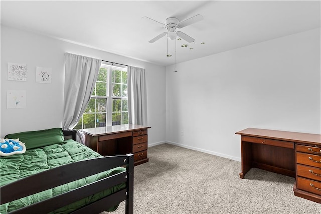 bedroom featuring light colored carpet, baseboards, and a ceiling fan