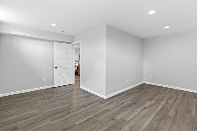spare room featuring recessed lighting, wood finished floors, and baseboards