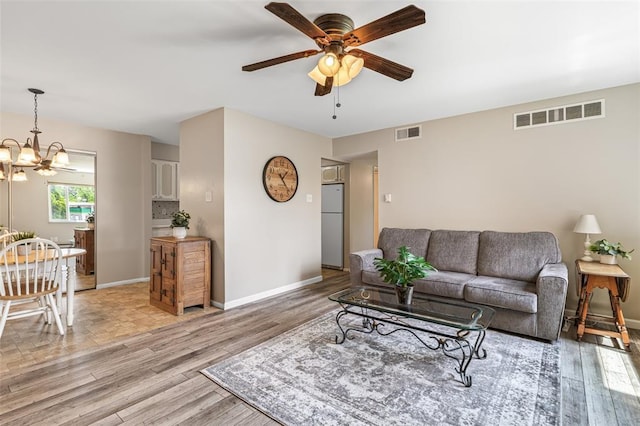 10003 Sakura Dr Unit B, Concord Township, MO 63128 - living room featuring a ceiling fan, light wood-style floors, a chandelier, and baseboards