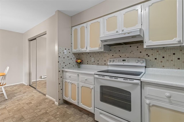 10003 Sakura Dr Unit B, Concord Township, MO 63128 - kitchen featuring white range with electric stovetop, under cabinet range hood, light countertops, backsplash, and baseboards