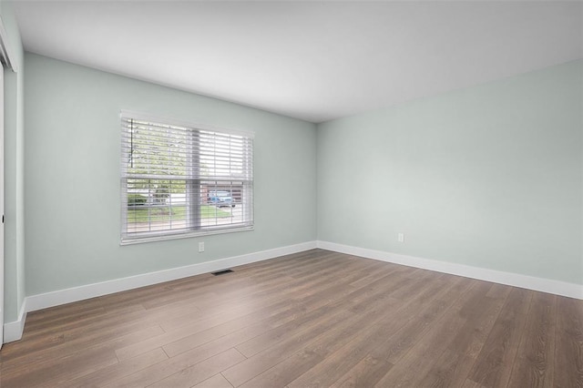 empty room with wood finished floors and baseboards