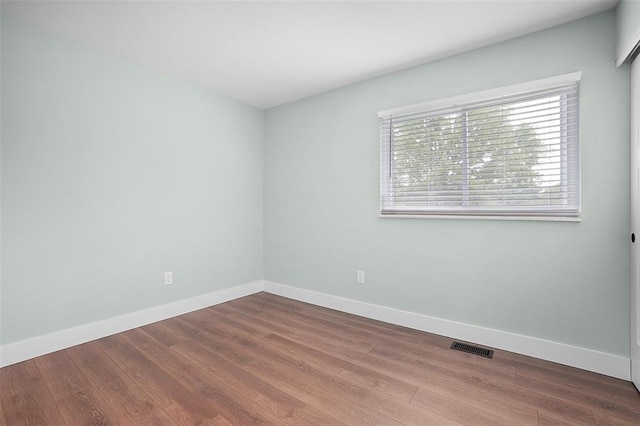 unfurnished room with wood finished floors and baseboards