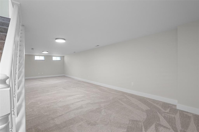 below grade area featuring carpet flooring, baseboards, and stairs