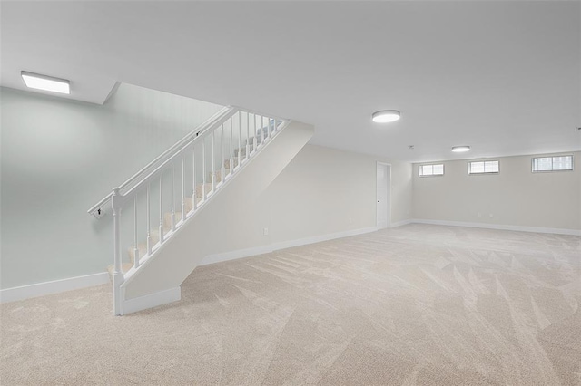 below grade area featuring carpet, stairway, and baseboards