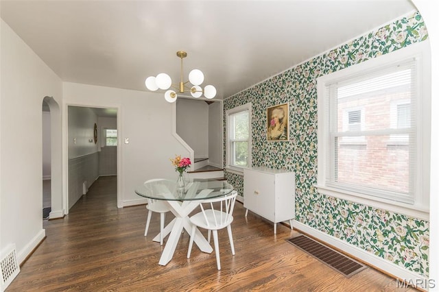2235 Brown Rd, Overland, MO 63114 - dining room with wallpapered walls, dark wood-style flooring, arched walkways, and a chandelier