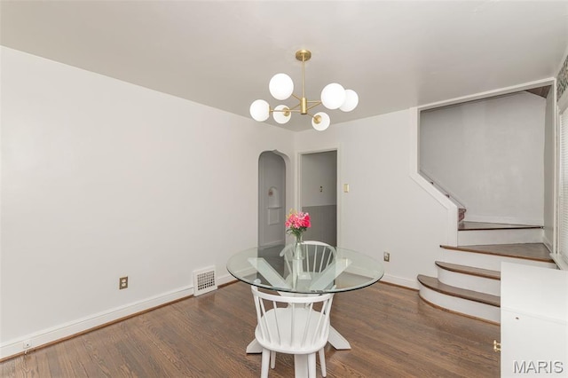 2235 Brown Rd, Overland, MO 63114 - dining space featuring arched walkways, wood finished floors, stairs, and a chandelier