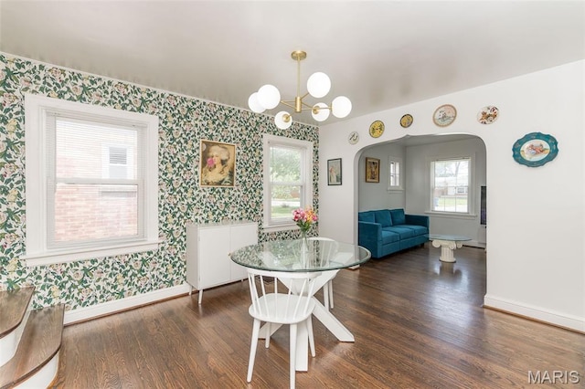 2235 Brown Rd, Overland, MO 63114 - dining room featuring wallpapered walls, arched walkways, dark wood-style flooring, and a chandelier