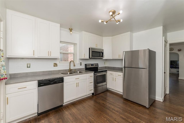 2235 Brown Rd, Overland, MO 63114 - kitchen featuring appliances with stainless steel finishes, white cabinets, a chandelier, and dark wood-type flooring