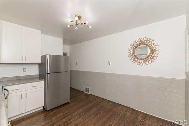 2235 Brown Rd, Overland, MO 63114 - kitchen featuring freestanding refrigerator, a chandelier, white cabinetry, a wainscoted wall, and dark wood-type flooring