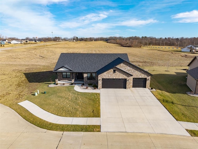 view of front facade with an attached garage, concrete driveway, a front yard, and brick siding