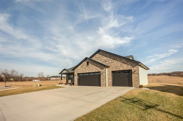 view of front facade featuring a garage, a front lawn, driveway, and brick siding
