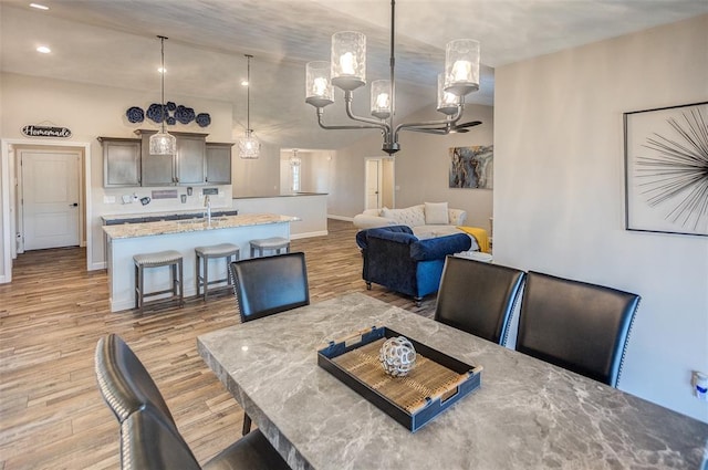 dining room with light wood-style floors, baseboards, a chandelier, and recessed lighting