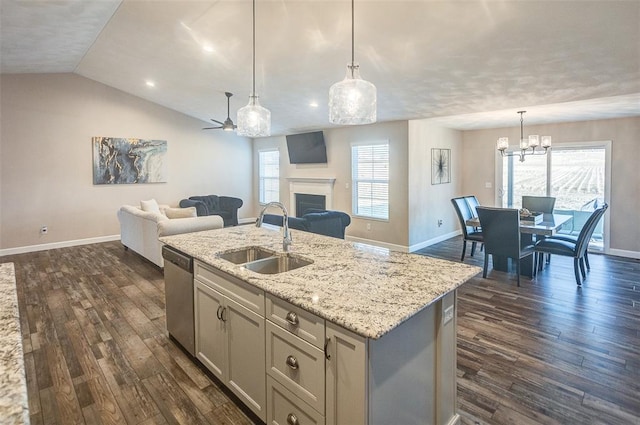 kitchen with a sink, stainless steel dishwasher, open floor plan, baseboards, and dark wood-style flooring