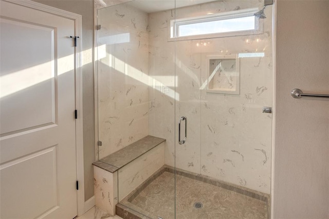 full bathroom with a stall shower and baseboards