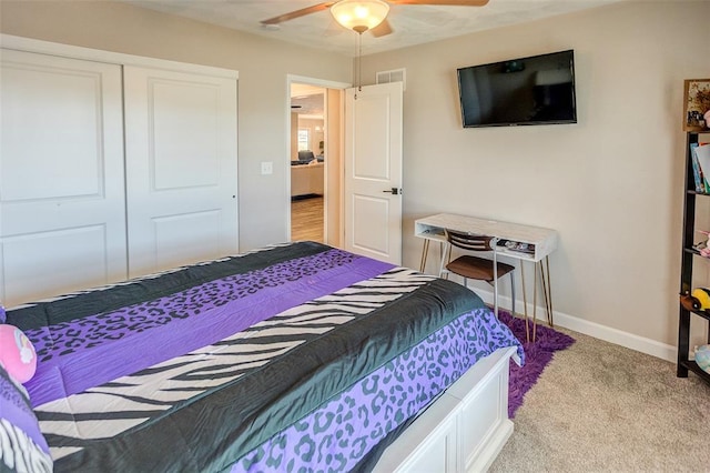 carpeted bedroom with baseboards, a closet, and a ceiling fan
