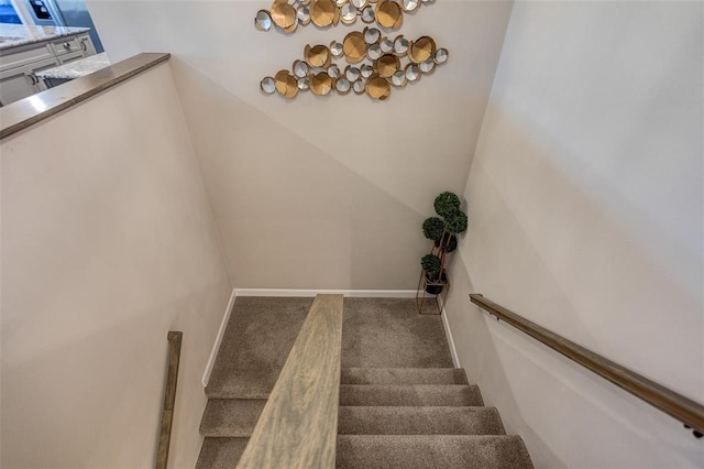 stairway featuring a chandelier and carpet