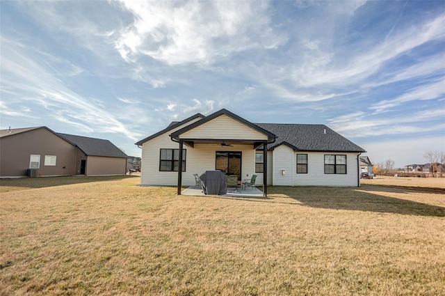 rear view of property with ceiling fan, a patio, and a lawn