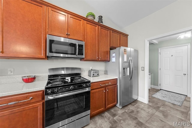 205 Stephanie Lynn Ct, Wentzville, MO 63385 - kitchen featuring appliances with stainless steel finishes, lofted ceiling, light countertops, and brown cabinetry