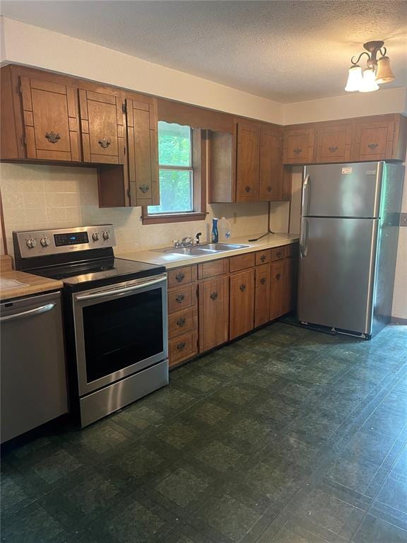 729 State Highway U, Burfordville, MO 63739 - kitchen with stainless steel appliances, a sink, light countertops, brown cabinetry, and dark flooring