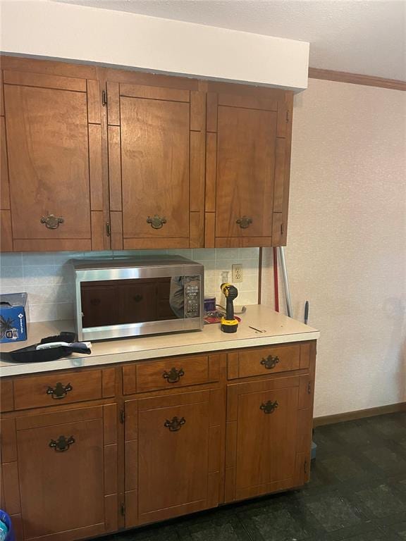 729 State Highway U, Burfordville, MO 63739 - kitchen view of stainless steel microwave, brown cabinets, light countertops, baseboards, and tasteful backsplash