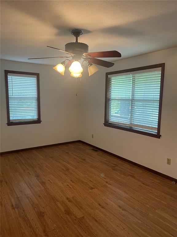 729 State Highway U, Burfordville, MO 63739 - spare room featuring healthy amount of natural light, a ceiling fan, baseboards, and wood finished floors