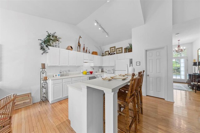 1008 Shire Ln, Eureka, MO 63025 - kitchen with white appliances, a chandelier, a breakfast bar, light wood-style floors, and track lighting