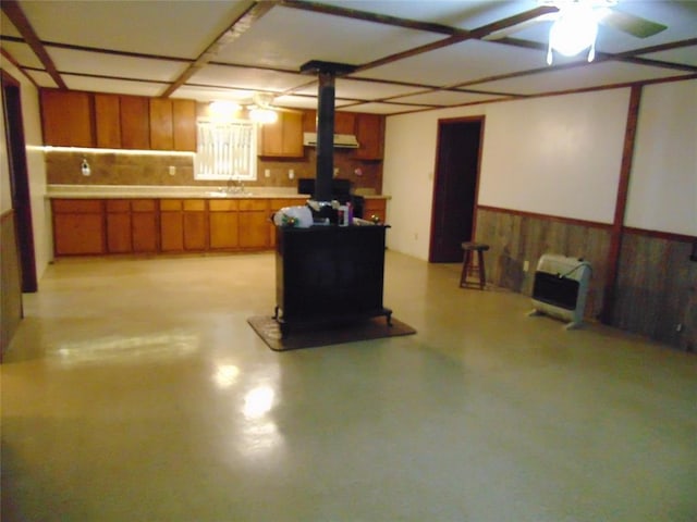 1184 Ripley 21n-10, Doniphan, MO 63935 - basement featuring a wood stove, a ceiling fan, wooden walls, a wainscoted wall, and heating unit