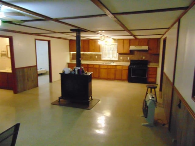 1184 Ripley 21n-10, Doniphan, MO 63935 - kitchen featuring black range with gas cooktop, ventilation hood, a wood stove, brown cabinets, and light countertops