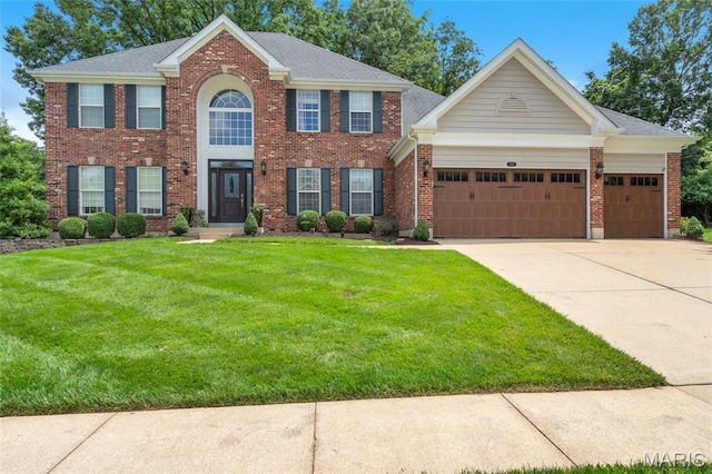 556 Autumn Bluff Dr, Ellisville, MO 63021 - colonial-style house featuring a front yard, driveway, a garage, and brick siding