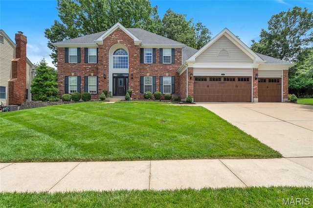 556 Autumn Bluff Dr, Ellisville, MO 63021 - colonial home featuring an attached garage, a front yard, brick siding, and concrete driveway