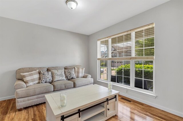 living area featuring baseboards and light wood-type flooring