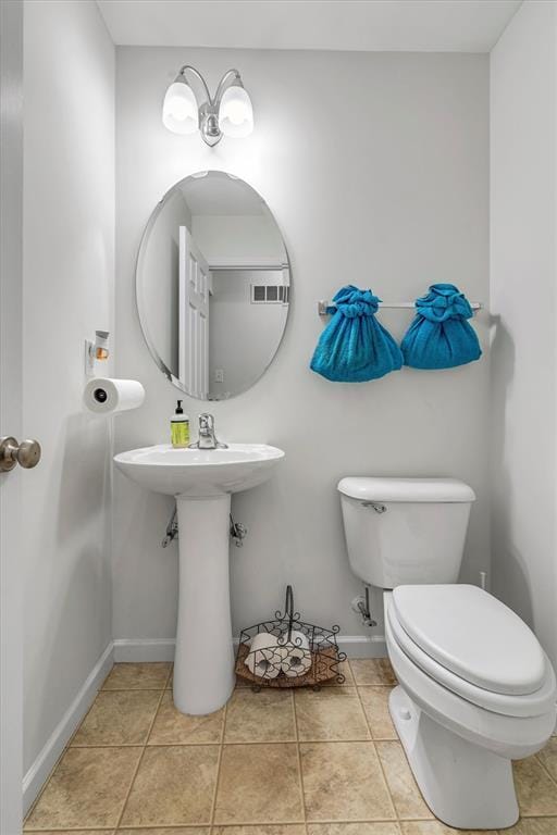 bathroom featuring toilet and baseboards