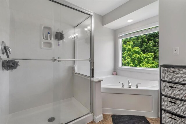 full bathroom featuring a garden tub and a shower stall
