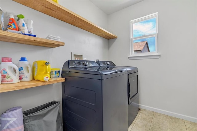 laundry area with washer and dryer, baseboards, and light tile patterned floors