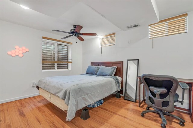 bedroom featuring light wood finished floors, baseboards, and ceiling fan