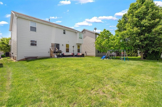 rear view of house with a playground, a lawn, and a patio area
