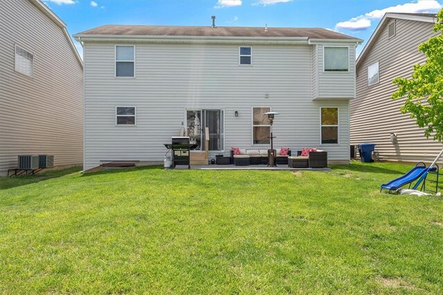 rear view of house featuring an outdoor living space, a lawn, a patio, and central AC