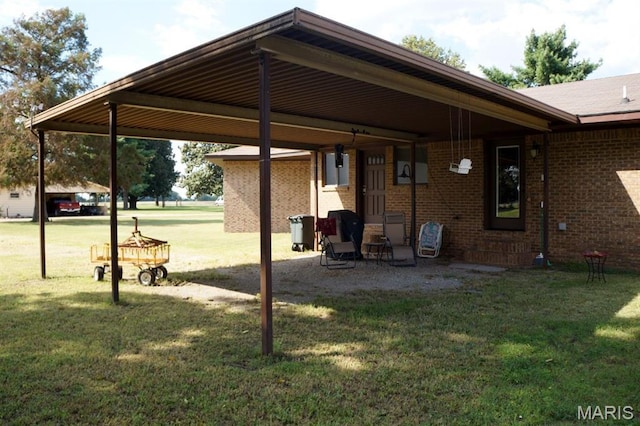 7526 State Highway 164, Cardwell, MO 63829 - rear view of house featuring brick siding, a lawn, and a carport