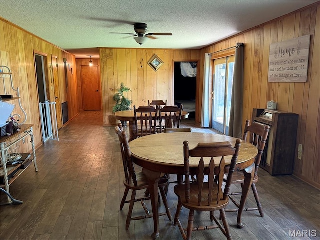 7526 State Highway 164, Cardwell, MO 63829 - dining area featuring wooden walls, dark wood finished floors, ceiling fan, and a textured ceiling