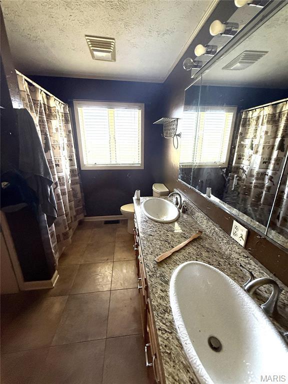 7526 State Highway 164, Cardwell, MO 63829 - full bath with double vanity, a textured ceiling, tile patterned flooring, and curtained shower