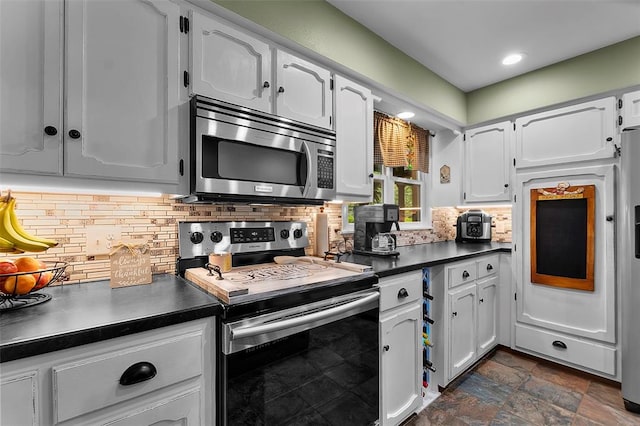 kitchen featuring appliances with stainless steel finishes, dark countertops, white cabinets, tasteful backsplash, and recessed lighting