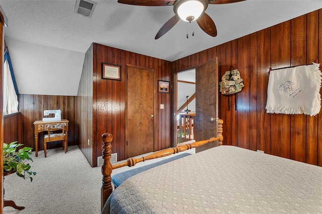 carpeted bedroom with wood walls and ceiling fan