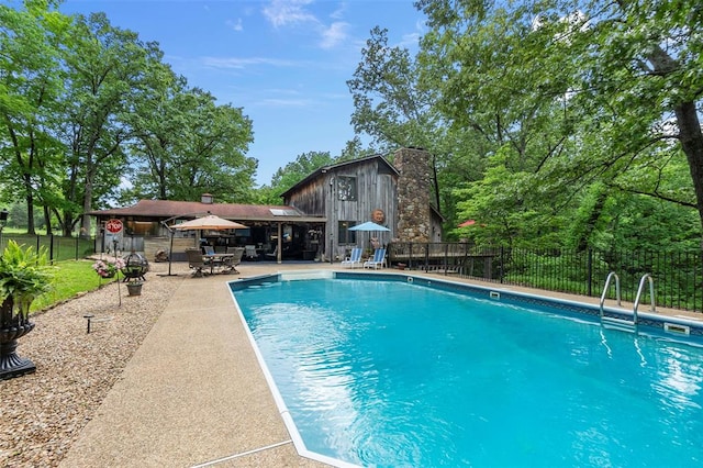 view of swimming pool featuring fence and a patio area