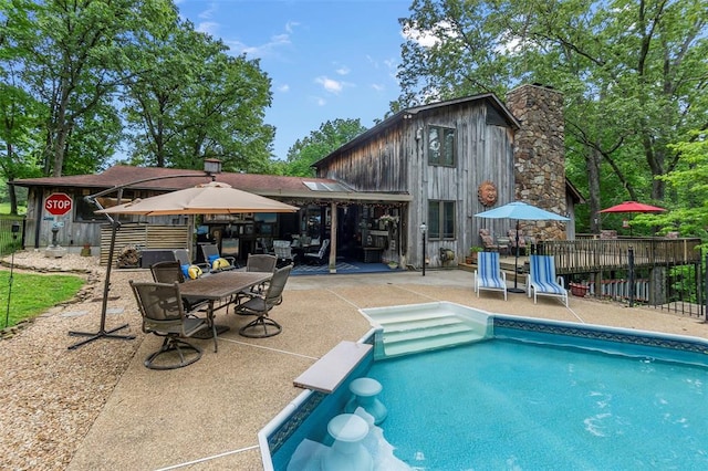 view of swimming pool featuring a patio area, fence, and outdoor dining space