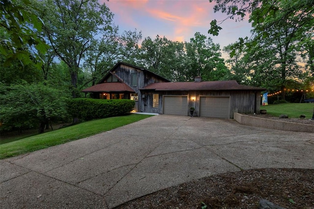 view of front facade featuring a garage, a front lawn, and concrete driveway
