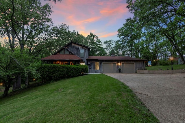 split level home featuring a garage, a lawn, and asphalt driveway