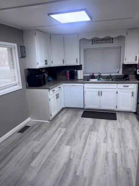 313 W Crumb Ave, Bernie, MO 63822 - kitchen with white dishwasher, a sink, white cabinetry, and light wood-style flooring