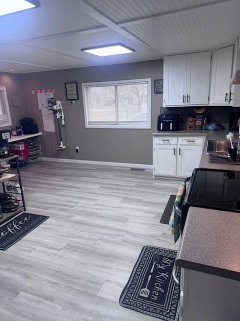 313 W Crumb Ave, Bernie, MO 63822 - kitchen with white cabinets, a sink, baseboards, and light wood-style floors